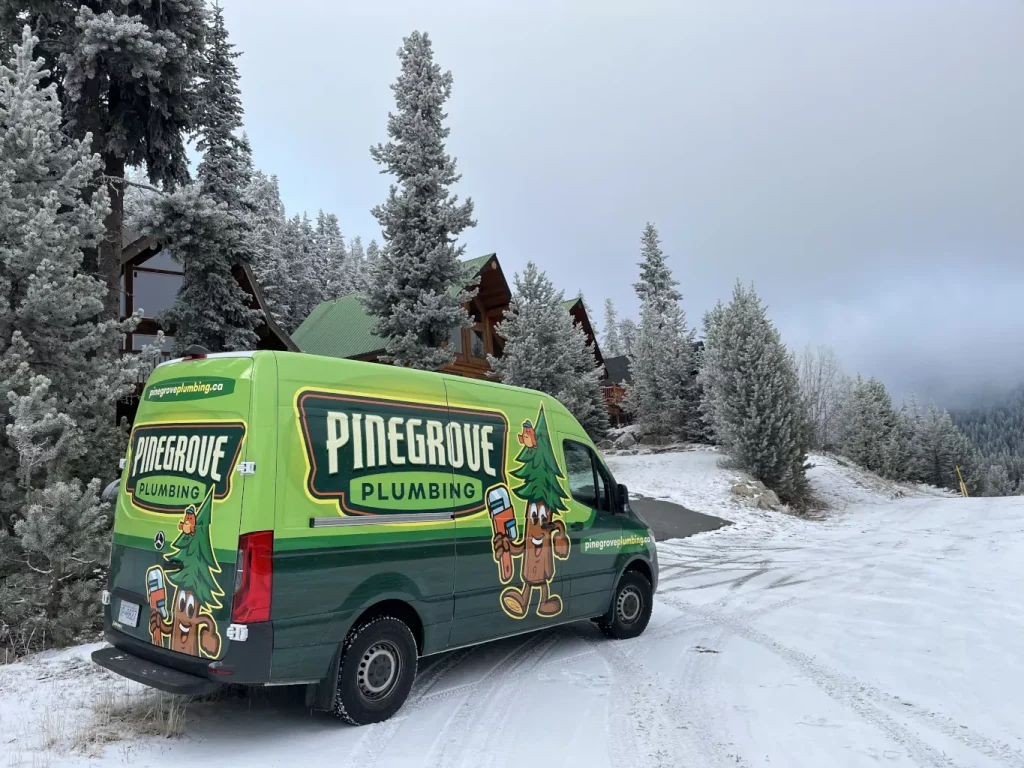 Pinegrove van next to a group of cabins on a snowy day