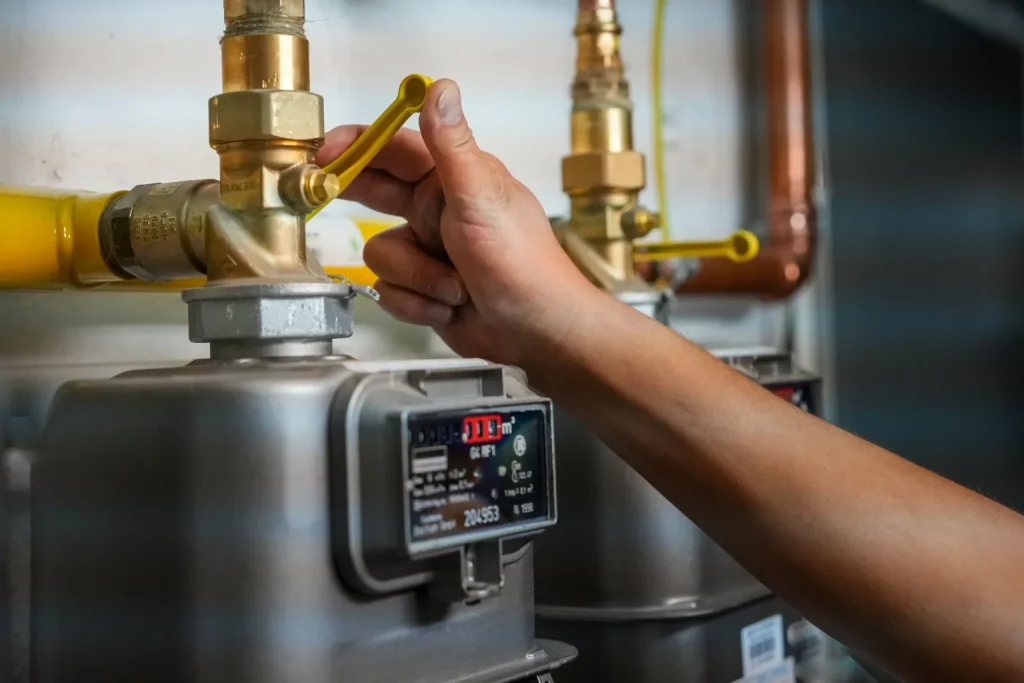 Person adjusting a gas meter