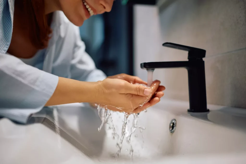 Woman washing her face in the bathroom