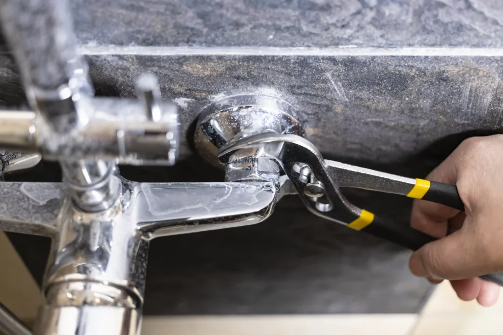 plumber unscrews nut of shower faucet