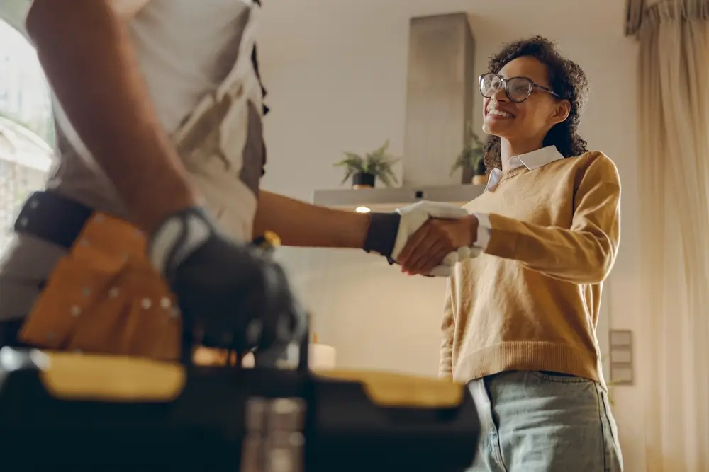 Handyman handshaking woman